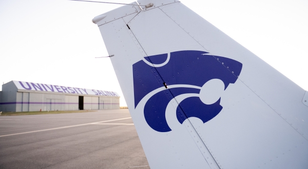A purple Powercat logo on the tail of a K-State Salina aircraft located on the campus runway.