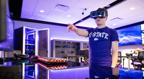 A student wears a VR headset while exploring during class on campus.
