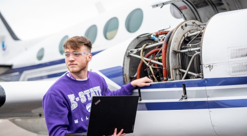 A student uses a laptop to help maintain aircraft at the K-State Salina campus.