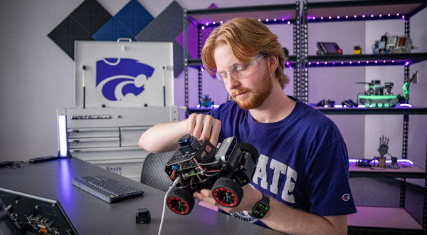 K-State Salina student tinkers with a robotics rover inside of an on-campus laboratory.