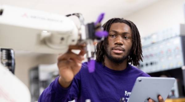 A Machine Learning and Autonomous Systems student at K-State Salina programs a robot to work autonomously.