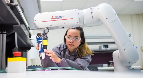 Student utilizing one of the robotic arms at the K-State Salina campus