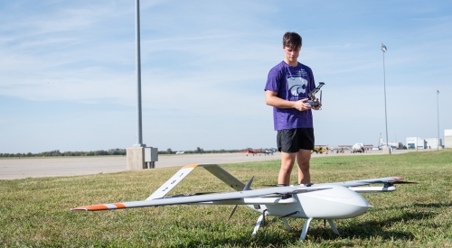 A UAS student readies to fly a drone near the K-State Salina campus