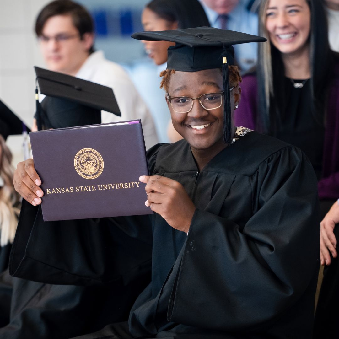 Image of K-State Salina student holding his degree at graduation