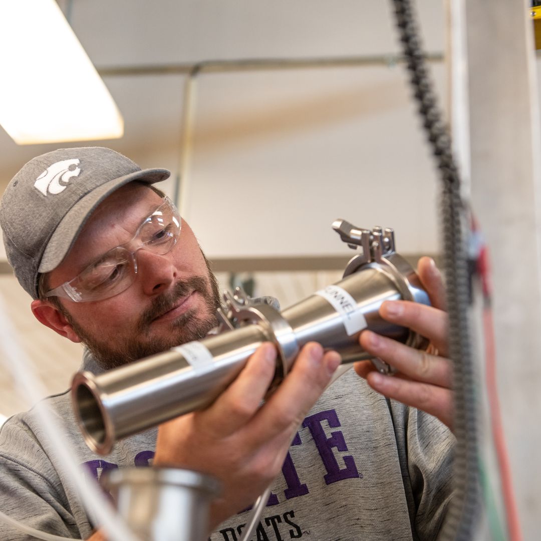 A student works on a piece of manufacturing equipment in the mechanical engineering technology lab at the K-State Salina campus.