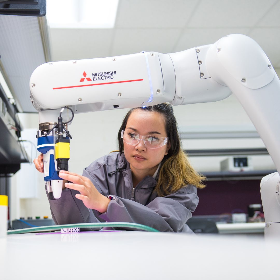A student works with a robotic arm at the K-State Salina campus apart of the robotics and automation technology degree. 