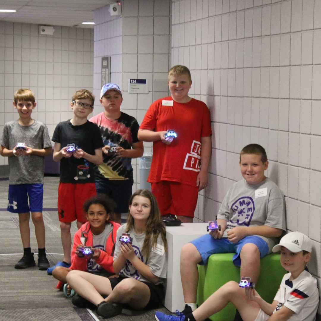 Students in the Build-a-Bot summer camp hold up their created robots at K-State Salina