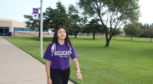 A student walks and enjoys the K-State Salina campus.
