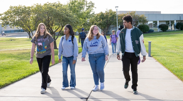 A group of students walk and converse during a beautiful evening at the K-State Salina campus