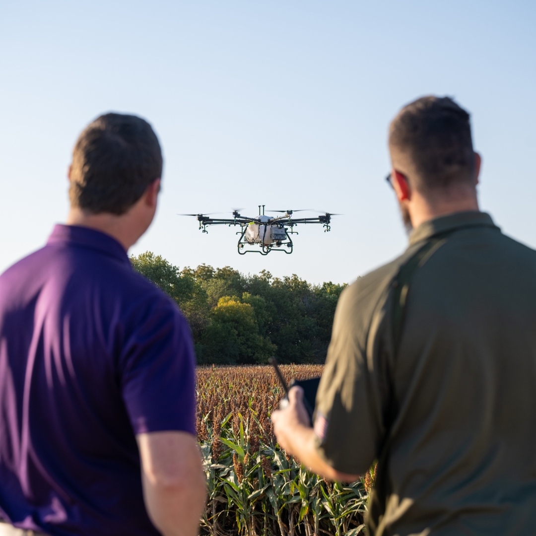 A K-State Salina UAS instructor teaches a learner how to operate a drone and also use the drone to spray an agricultural field.