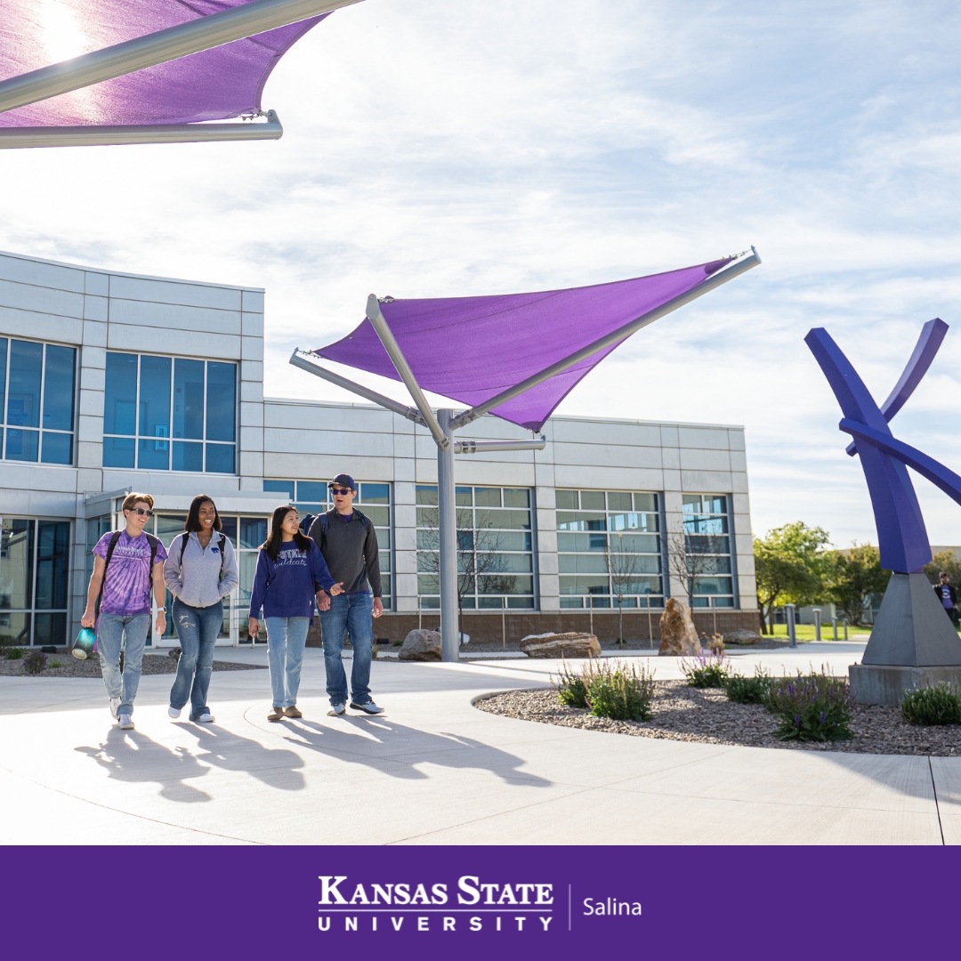 Four students walking on the K-State Salina campus on bright, sunshining day.