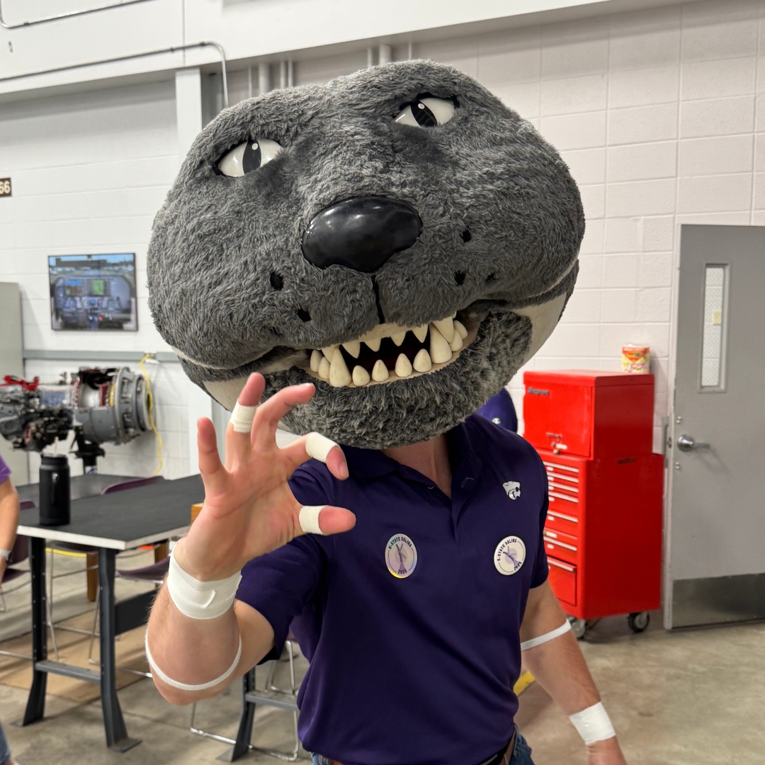 Willie the Wildcat gestures the Wildcat hand sign. 