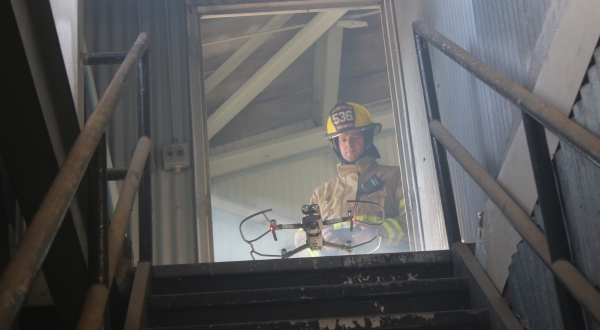 A firefighter operates a drone in a smoky building. K-State's Applied Aviation Research Center provides UAS training for public safety.