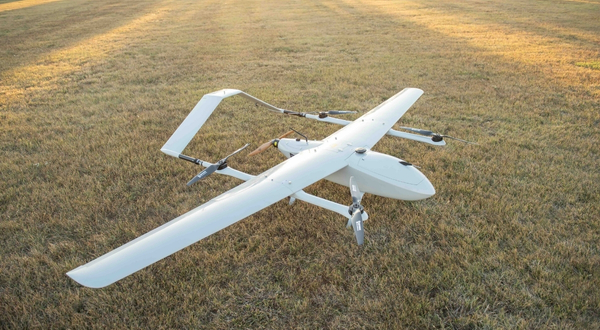 A K-State Salina Great Shark drone while the sun sets in the background in a grassy field.