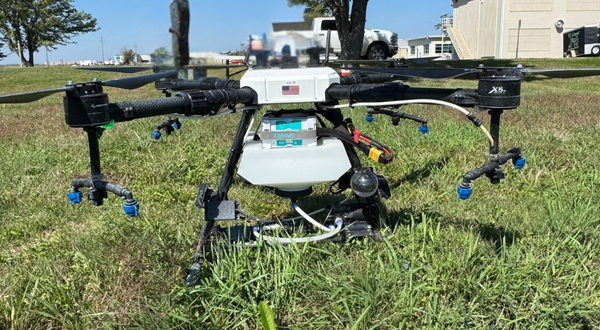 A Hylio AG 210 UAS with spraying capabilities offered at K-State Salina sits in a grass field on a sunny day.