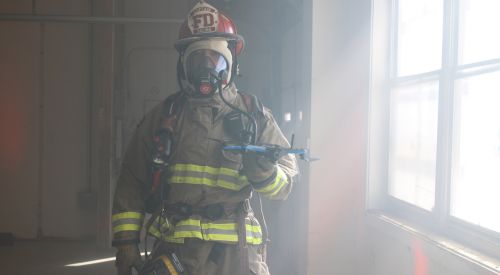 A firefighter holds a drone in a smoky building. K-State Salina's UAS professionals offering elite training in Fire and HAZMAT response  utilization of drones.