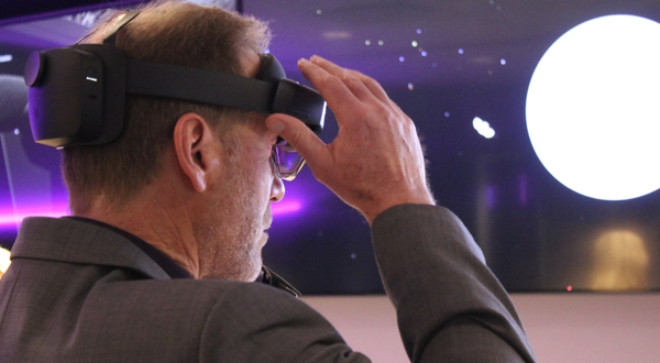 A subject grips a VR headset as he explores a virtual world inside of a laboratory.